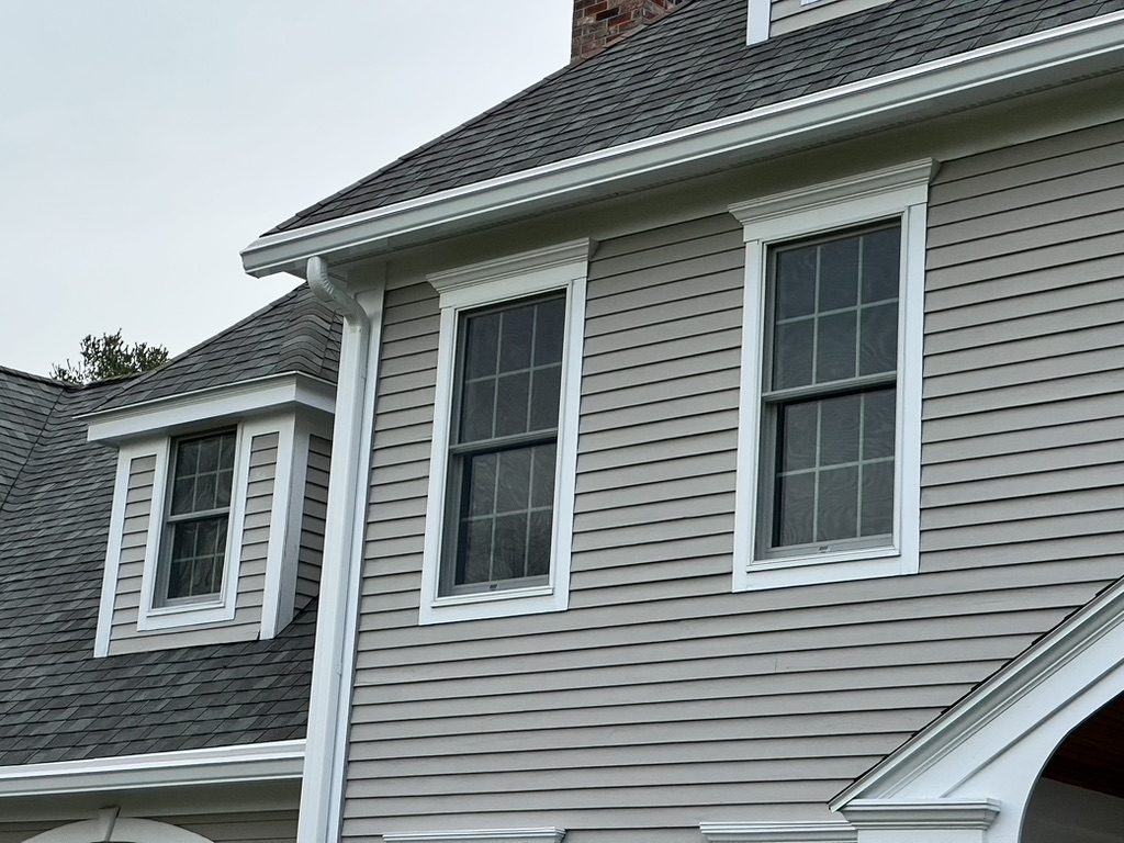 Gray colonial home showing gutter run and downspout